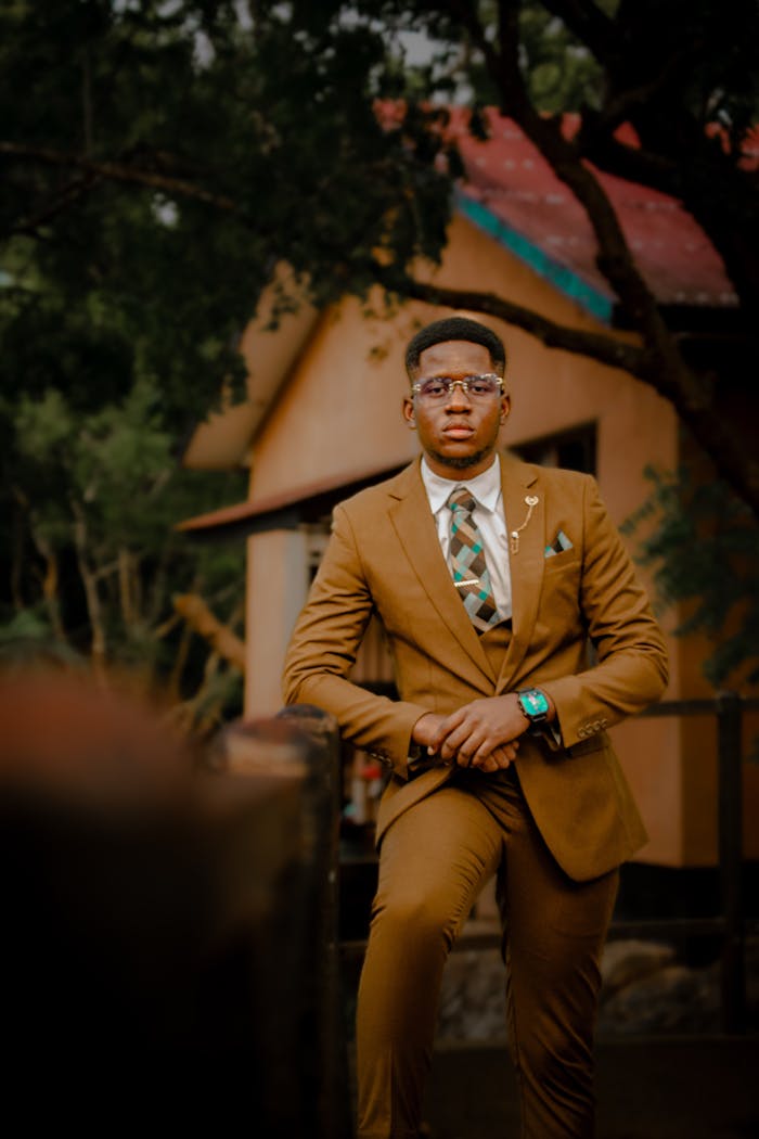 Portrait of a stylish man in a brown suit standing confidently outdoors in Dar es Salaam, Tanzania.